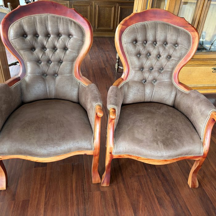 Dos sitiales antiguos de cuero y madera.